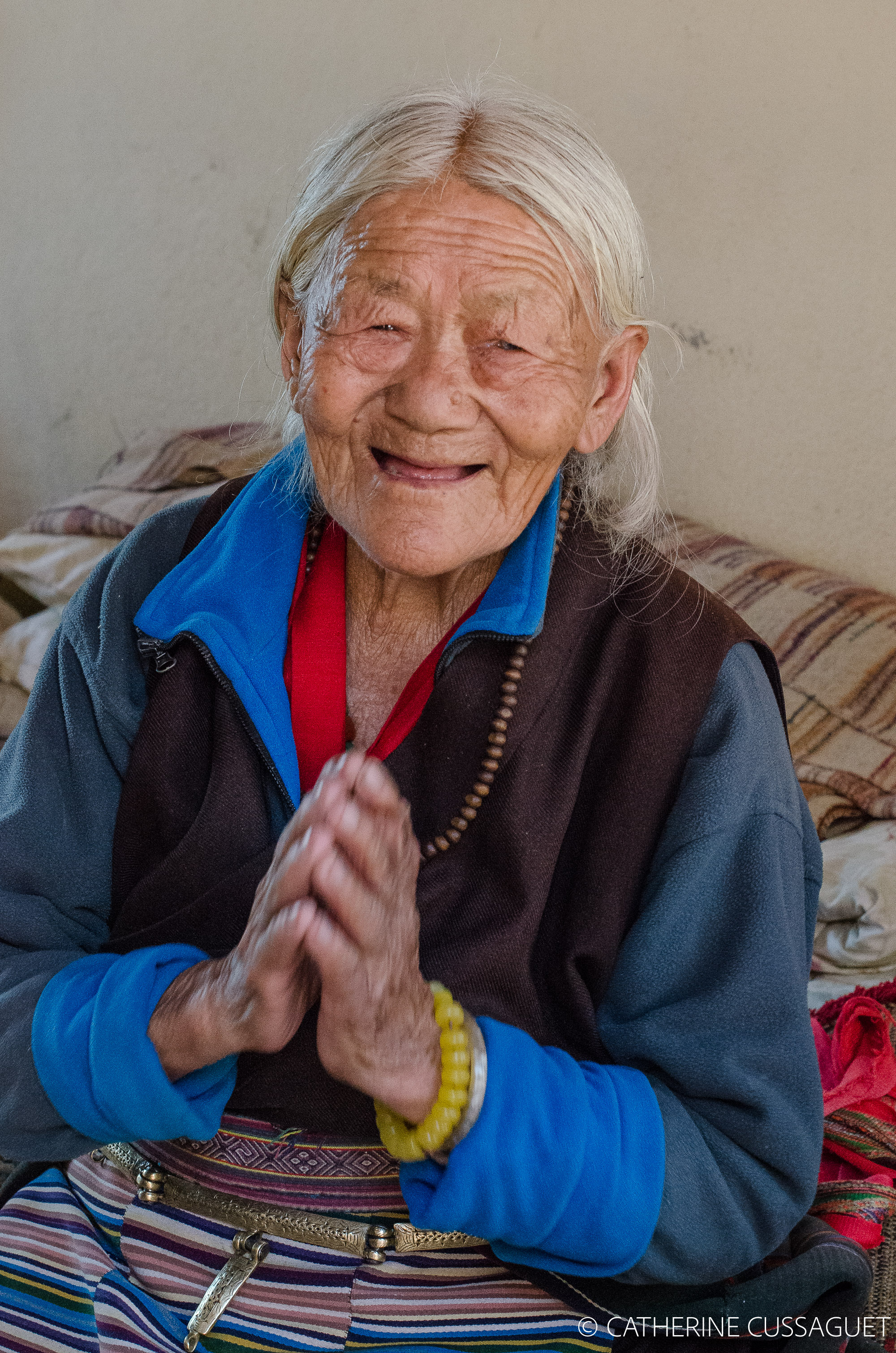 Old Tibetan woman giving thanks