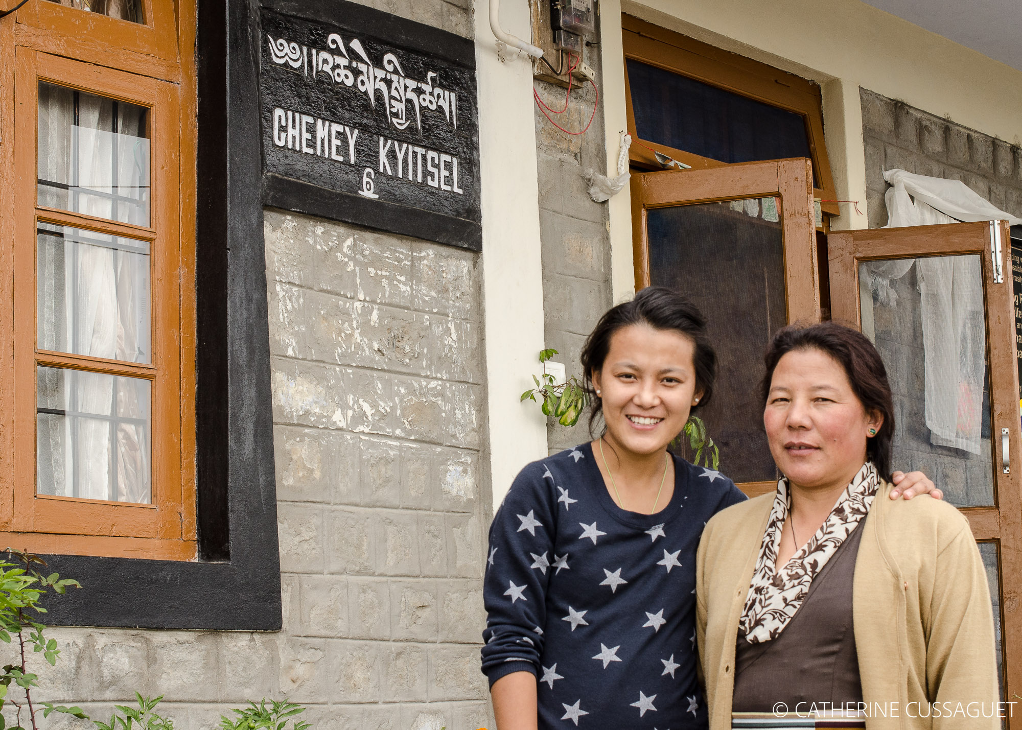 Mother and daughter in front of house
