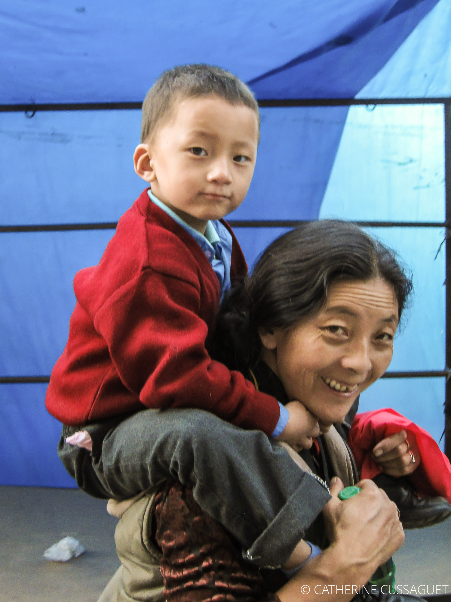 Child on mother's shoulders.